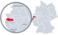 Diese Grafik zeigt eine Karte von Deutschland mit einer detaillierten Ansicht der Region Düsseldorf-BergischLand. Düsseldorf-BergischLand ist in Rot hervorgehoben und liegt im westlichen Teil Deutschlands. Ein Lupensymbol vergrößert diesen Bereich, um die Lage genauer darzustellen.