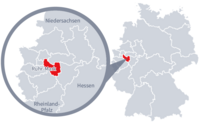 Diese Grafik zeigt eine Karte von Deutschland mit einer detaillierten Ansicht der Region Ruht-Mark. Ruht-Mark ist in Rot hervorgehoben und liegt im westlichen Teil Deutschlands. Ein Lupensymbol vergrößert diesen Bereich, um die Lage genauer darzustellen.