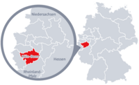 Diese Grafik zeigt eine Karte von Deutschland mit einer detaillierten Ansicht der Region Köln-Bonn. Köln-Bonn ist in Rot hervorgehoben und liegt im westlichen Teil Deutschlands. Ein Lupensymbol vergrößert diesen Bereich, um die Lage genauer darzustellen.